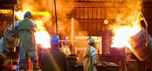 Foundry workers managing metal casting process.